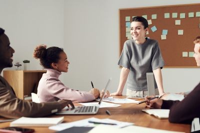 Woman-smiling-in-grey-in-office-with-group